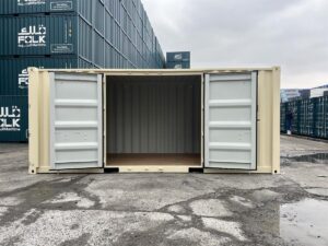 A wide side view of the ivory shipping container with its side double doors fully swung open, revealing the empty interior. The inside walls are light gray corrugated steel, and the floor is made of smooth, warm-toned plywood.