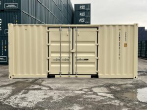 A wide, side-profile view of the ivory shipping container, highlighting the closed double doors centered on its long side panel. The container code "CPWU 090119 1" is printed vertically on the right side. Large stacks of teal shipping containers form a dense background.